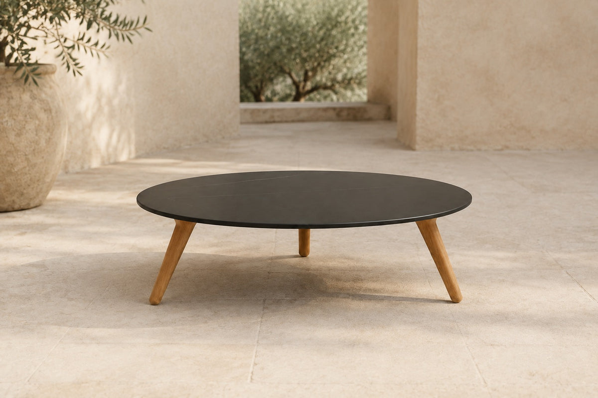 Marisol 90 cm coffee table with dark solid circular top and three timber legs, lifestyle room