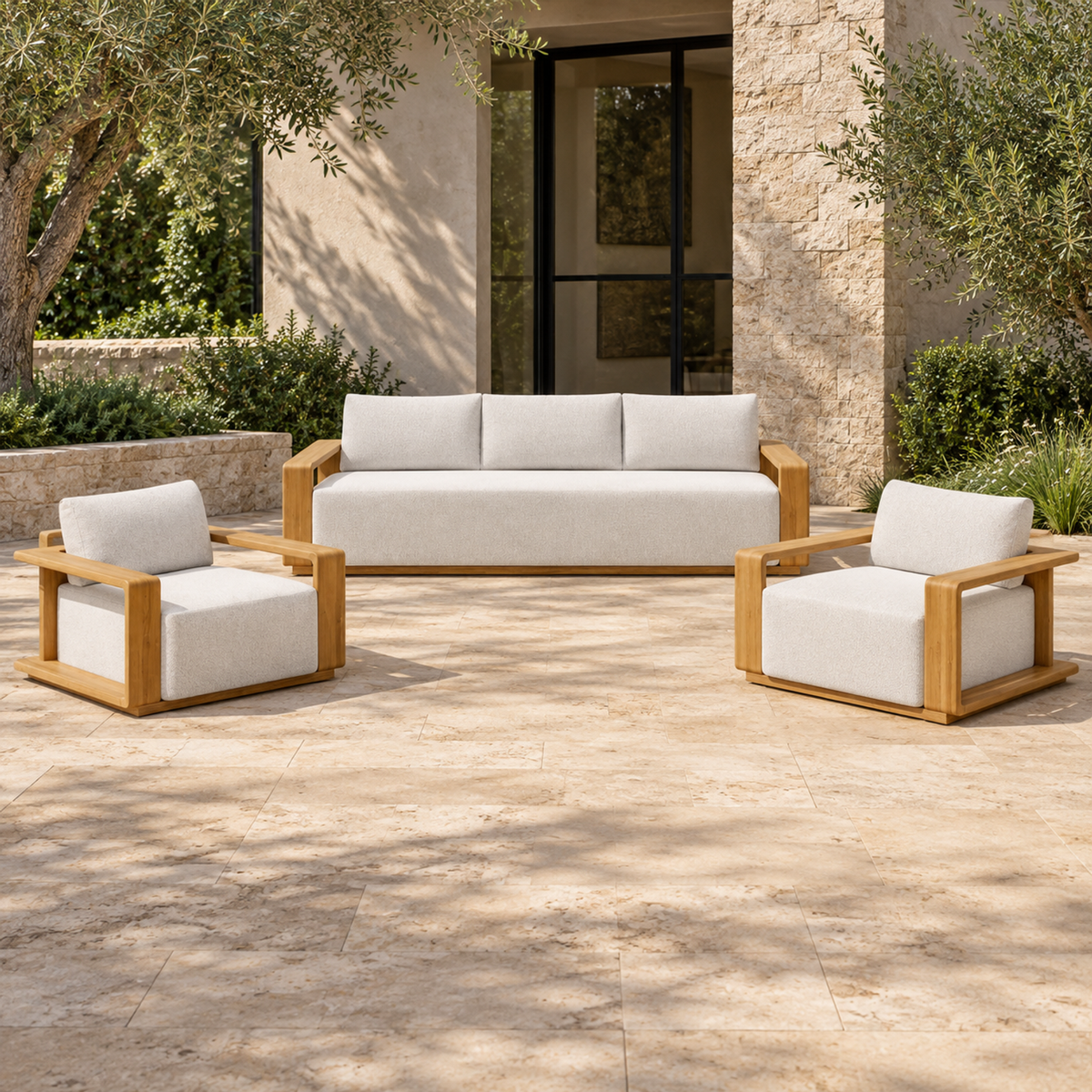 Grace teak sofa and two lounge chairs, front view on a planted stone terrace