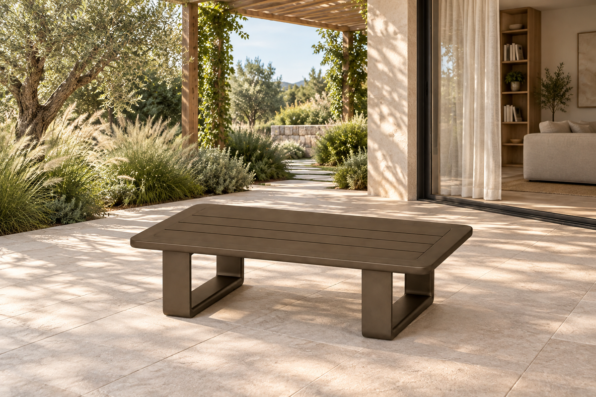 Lifestyle view: Grace coffee table in aluminium on a garden terrace beside a furnished home.