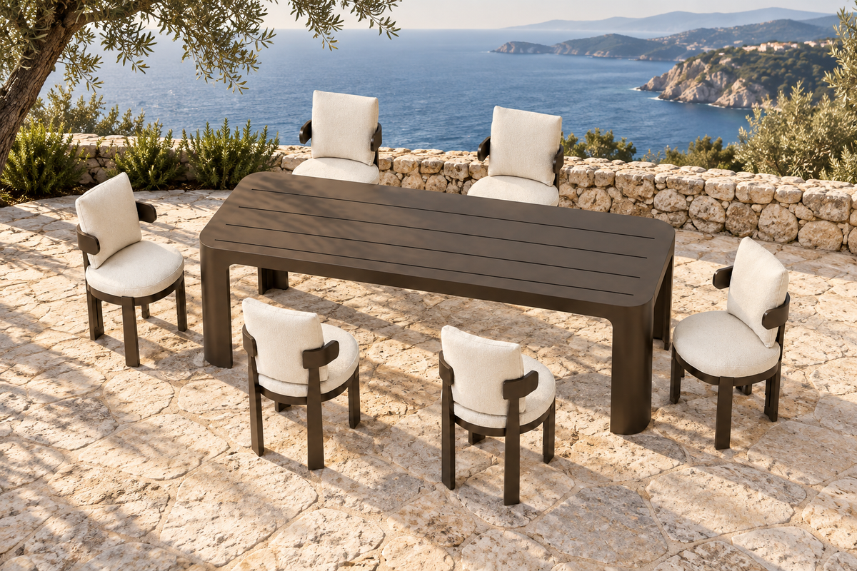 Lifestyle view: Serein aluminium dining table and six chairs on a coastal stone terrace