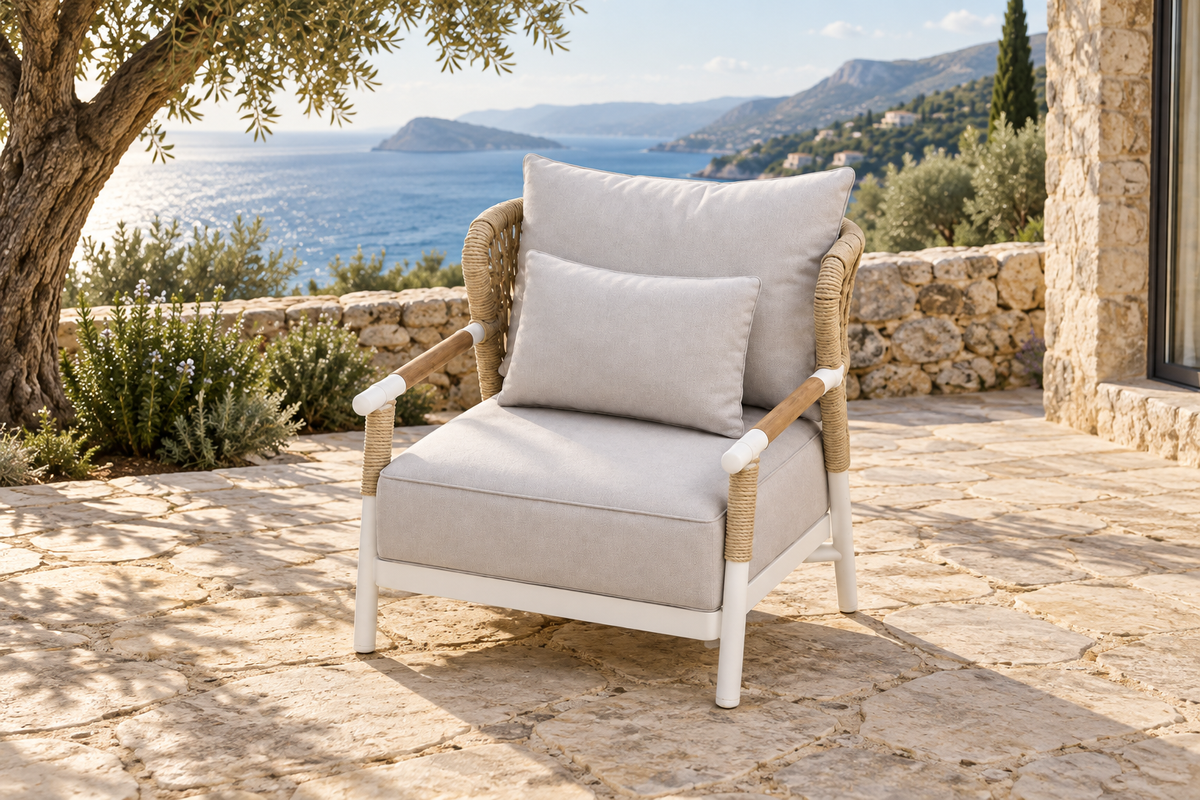 Lifestyle view: Vela aluminium lounge chair on a coastal stone terrace.