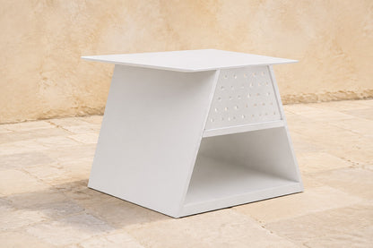 Luna Occasional Table in Aluminium, photographed in a quiet outdoor courtyard