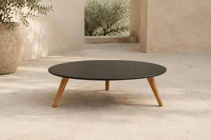 Marisol 90 cm coffee table with dark solid circular top and three timber legs, lifestyle room