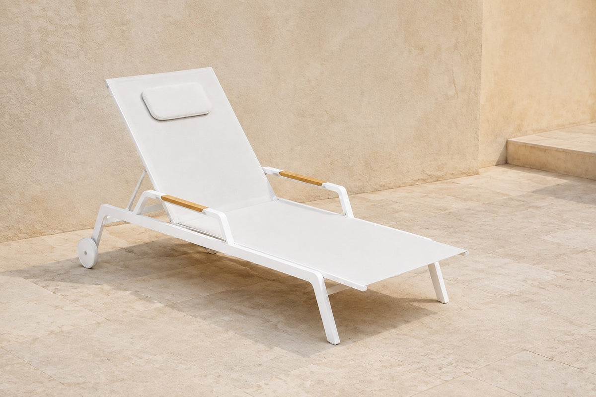 Vela Poolside Sun Lounger in Aluminium, photographed in a quiet outdoor courtyard