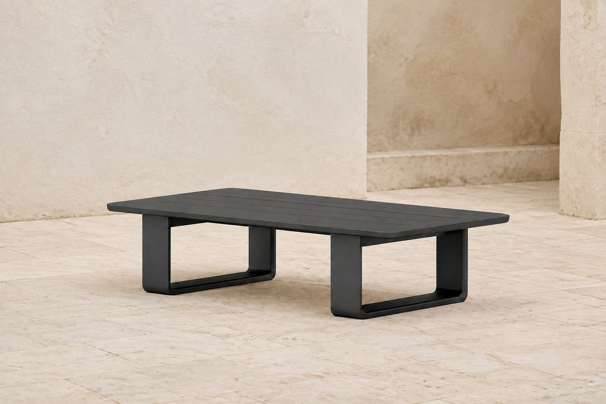 Zenia Coffee Table in Aluminium, photographed in a quiet outdoor courtyard