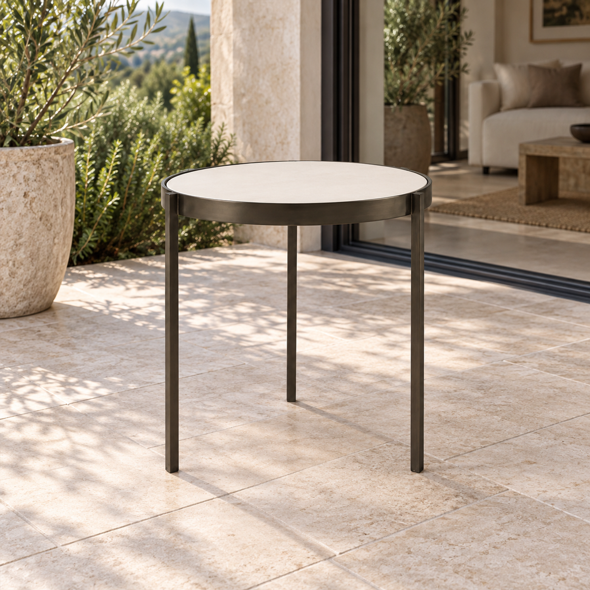 Lifestyle view: Amalfi Coffee Table, 40 cm, photographed in a quiet outdoor courtyard