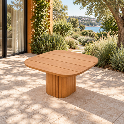Lifestyle view: Ethereal Side Table in Teak, opposite three-quarter view beside a coastal garden home