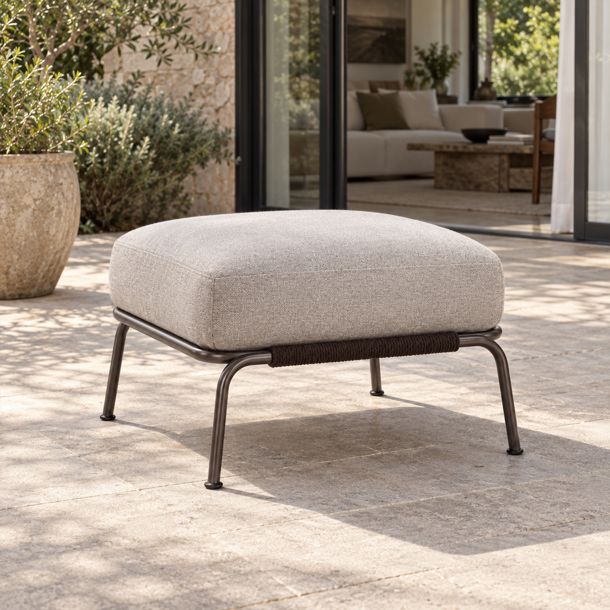 Lifestyle view: Ischia Ottoman, photographed in a quiet outdoor courtyard