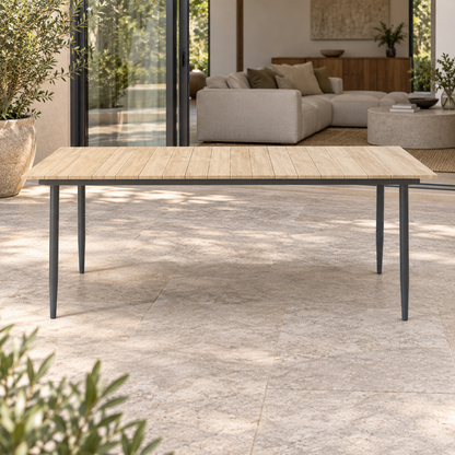 Lifestyle view: Naxos Dining Table, photographed in a quiet outdoor courtyard