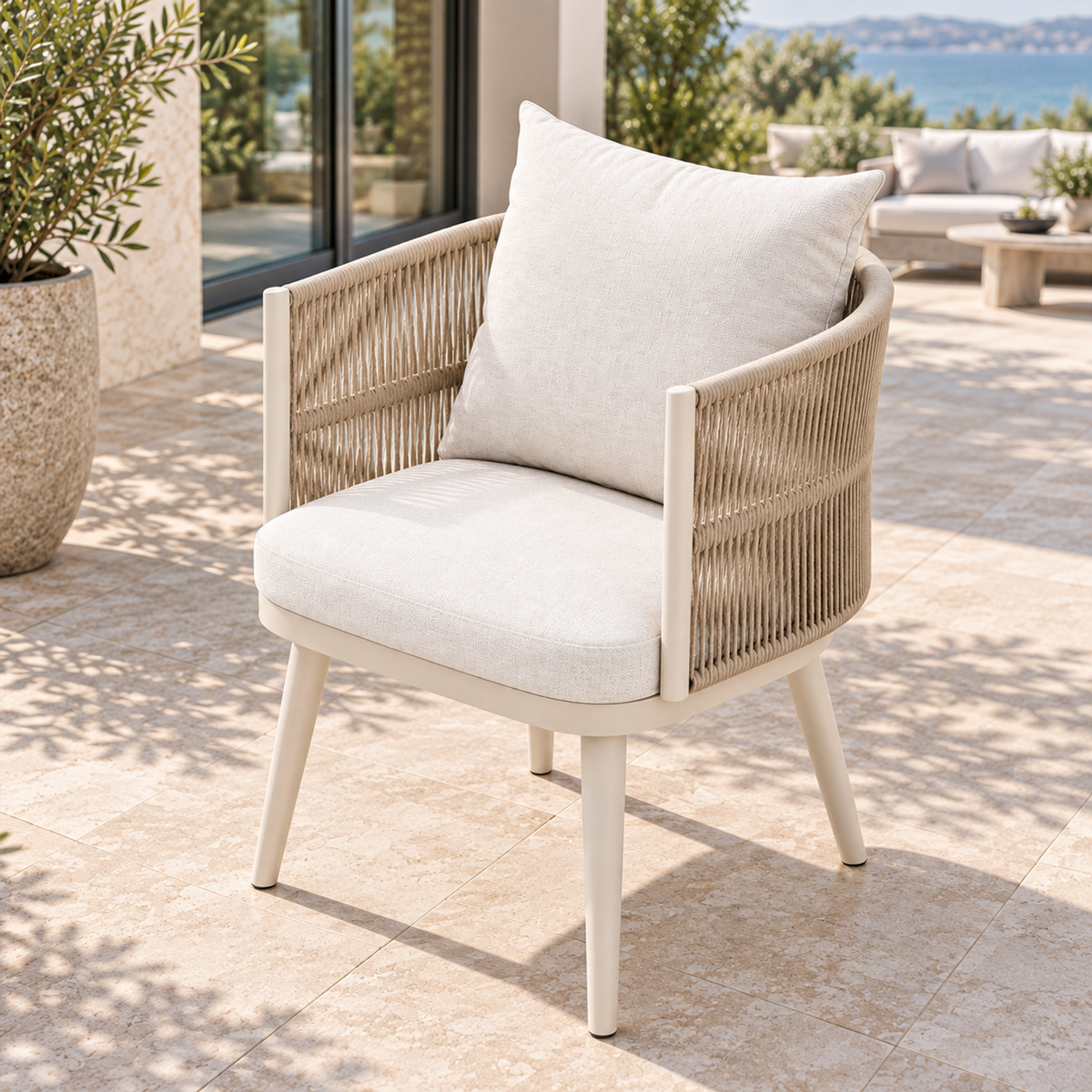Lifestyle view: Ripple Dining Chair in Aluminium, right diagonal on a furnished coastal terrace