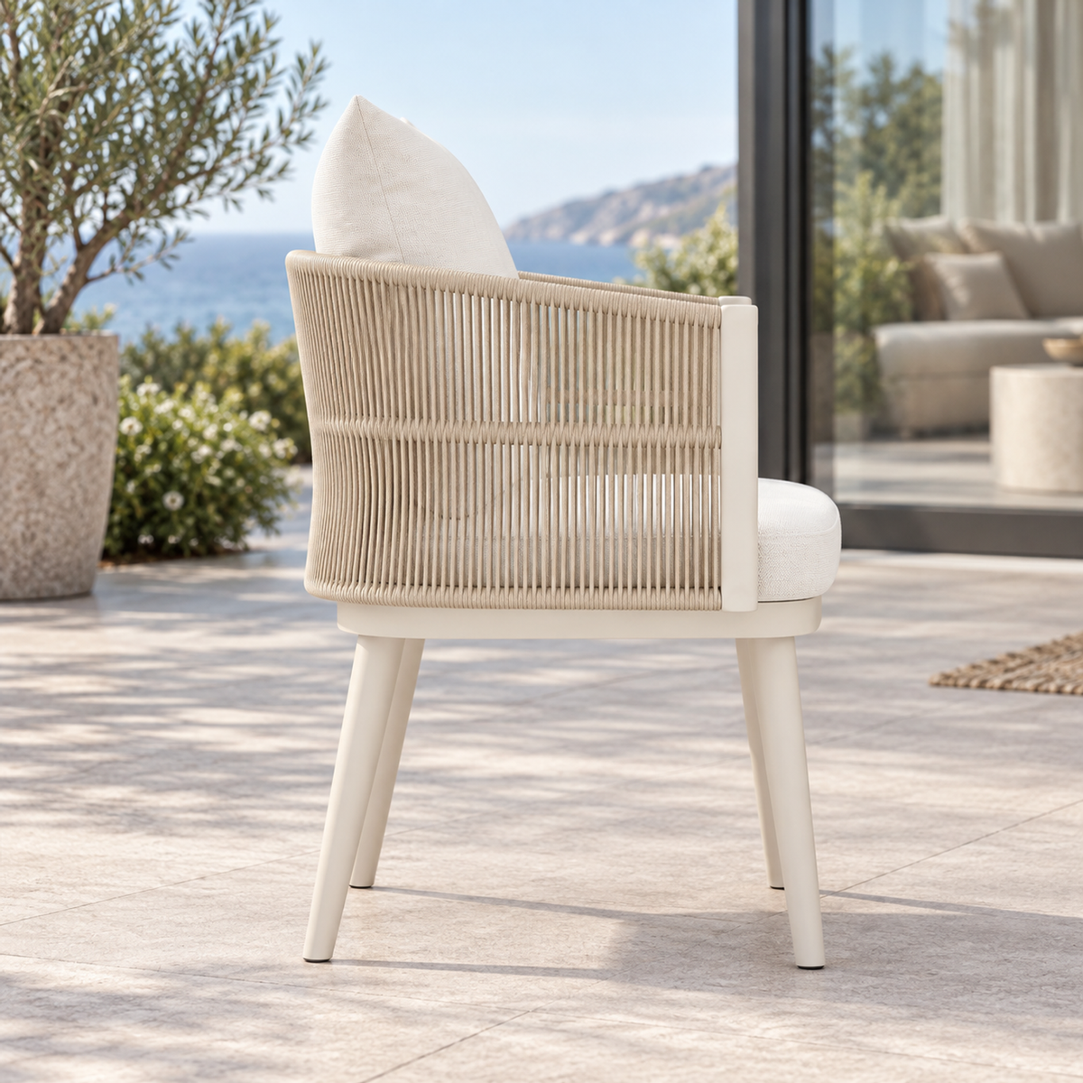 Lifestyle view: Ripple Dining Chair in Aluminium, side profile on a coastal terrace