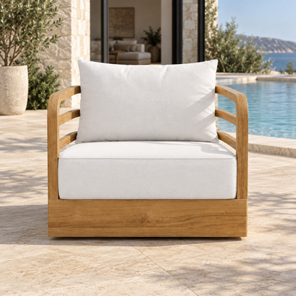 Vela teak lounge chair, front view beside a furnished home